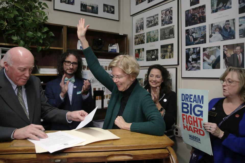 Democratic presidential candidate Sen. Elizabeth Warren, D-Mass., reacts after filing to have her name listed on the New Hampshire primary ballot, Wednesday, Nov. 13, 2019, in Concord, N.H. At left is New Hampshire Secretary of State Bill Gardner. (AP Photo/Charles Krupa)