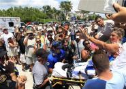 U.S. long-distance swimmer Diana Nyad, 64 (R) waves to the crowd from a stretcher, after completing her swim from Cuba to Key West, Florida, September 2, 2013. REUTERS/Andrew Innerarity