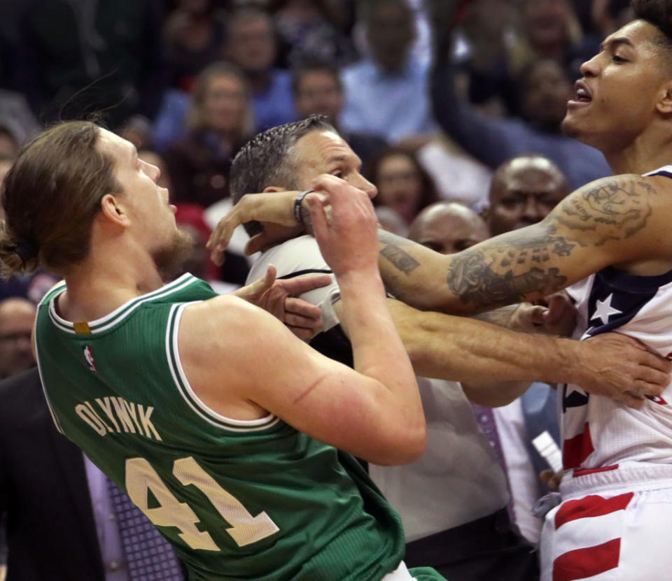 Wizards forward Kelly Oubre charges and knocks down Celtics center Kelly Olynyk. (The Boston Globe via Getty)