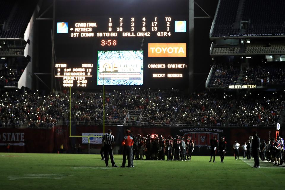 Fans and players look on while half of the stadiums lights went out during the second half of a game between the San Diego State Aztecs and the Stanford Cardinal at Qualcomm Stadium on September 16, 2017 in San Diego, California. (Photo by Sean M. Haffey/Getty Images)