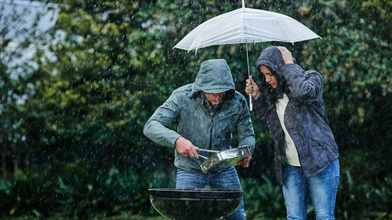 couple barbecue in the rain