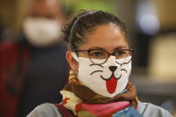 Una mujer con una máscara facial decorada con una cara de animal espera en línea para una prueba rápida de coronavirus en una estación de tren en Buenos Aires, Argentina, el viernes 24 de abril de 2020. (AP Foto / Natacha Pisarenko)