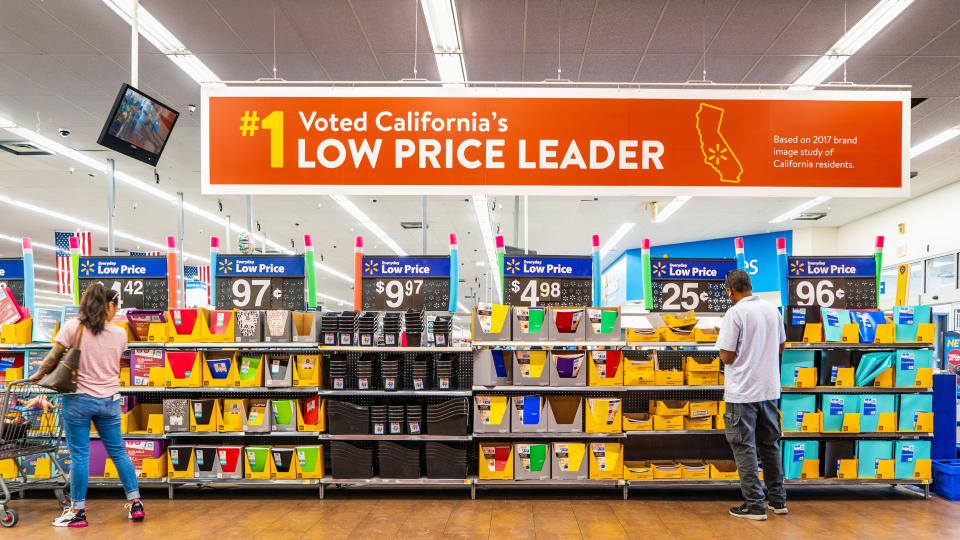 August 8, 2019 Mountain View / CA / USA - People shopping for back to school items in one of the Walmart stores; Banner advertising the low price leader status in California displayed above.