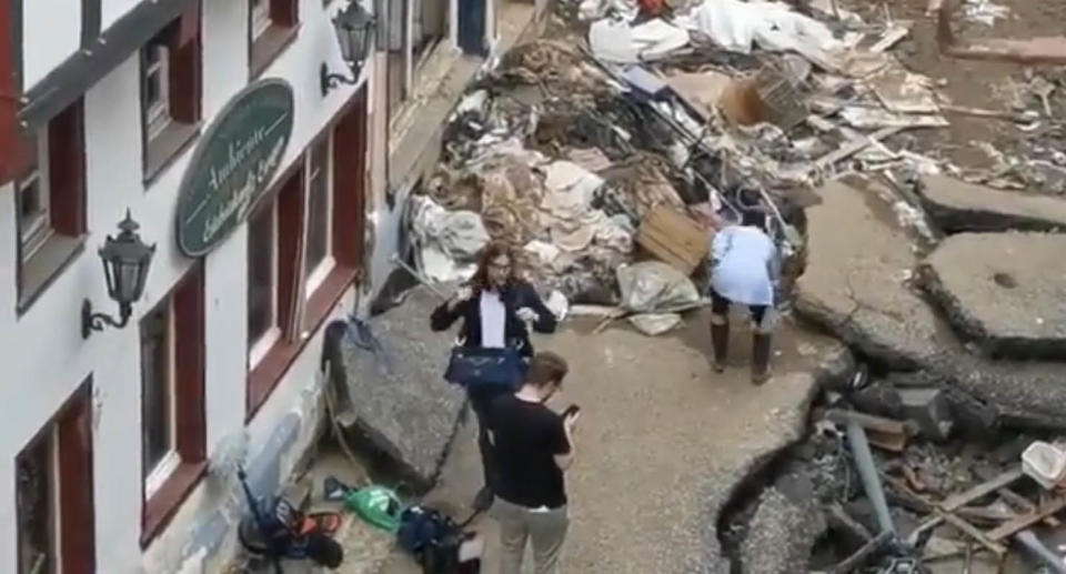 A screenshot of the video filmed by an onlooker which shows Susanna Ohlen touching muddy water with her hands and rubbing her face. Source: 