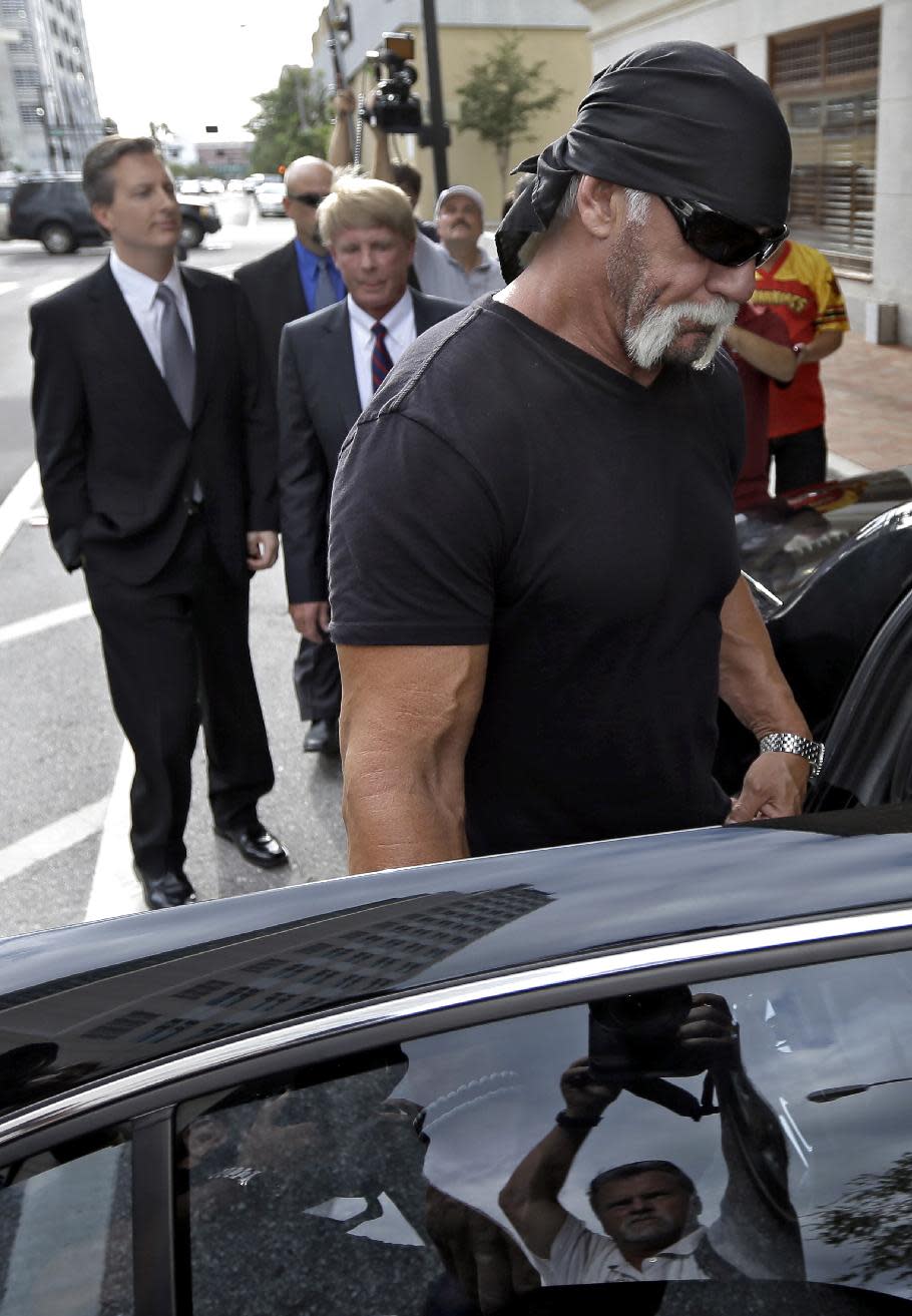 Reality TV star and former pro wrestler Hulk Hogan, right, whose real name is Terry Bollea, leaves the United States Courthouse with his attorneys David Houston, center, and Charles Harder, left, for a news conference Monday, Oct. 15, 2012 Tampa, Fla. Hogan says he was secretly taped six years ago having sex with the ex-wife of DJ Bubba "The Love Sponge" Clem. Portions of the video of Hogan and Heather Clem were posted on the online gossip site Gawker. (AP Photo/Chris O'Meara)