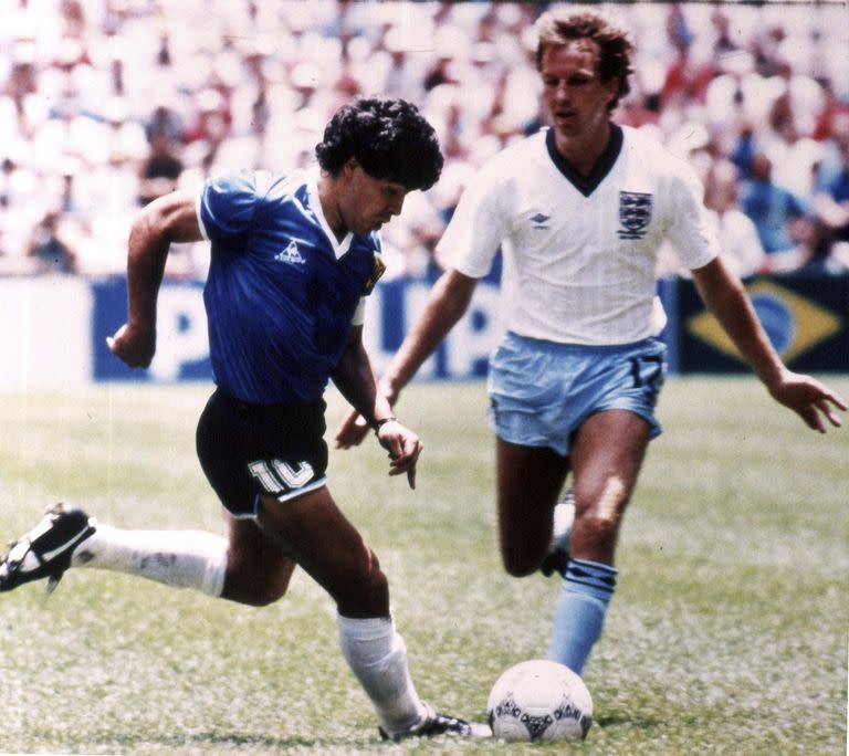 ARCHIVO - Diego Maradona (izquierda) esquiva al inglés Trevor Steven durante el partido de la Copa Mundial en el Estadio Azteca, el 22 de junio de 1986. La camiseta que usó el astro argentino en ese partido, en el que el controvertido gol de la “mano de Dios” y luego el mejor gol de la historia de los mundiales está en venta, y la subastadora Sotheby’s estima que recaudará más de 4 millones de libras (5,2 millones de dólares) en una subasta online que comienza el 20 de abril. (AP Foto)