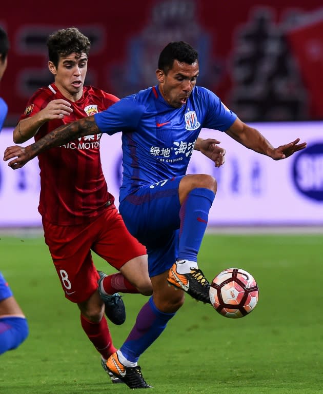 Shanghai Shenhua's Carlos Tevez is challenged by Shanghai SIPG's 60 million euro signing Oscar (left) in the city's fierce derby at the weekend. SIPG won 6-1