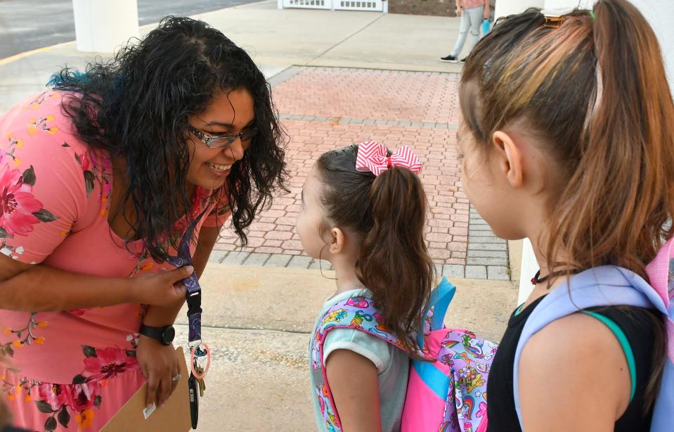 Kindergarten teacher Amanda Green greets Scarlett Kinzel, one of her students at Brevard Public School, as classes resumed last August.