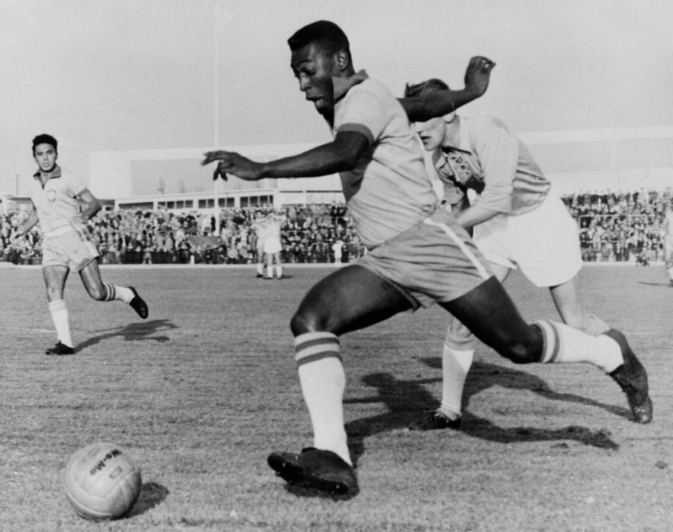 Brazilian forward Pele dribbles past a defender during a friendly match vs Malmoe in 1960 (AFP/Getty Images)