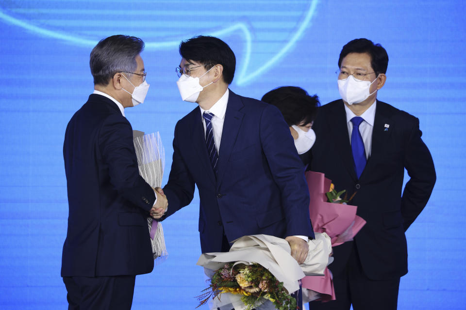 Gyeonggi Gov. Lee Jae-myung, left, one of the ruling Democratic Party's contenders for next year's presidential election, shakes hands with another candidate Park Yong-jin after winning the final race to run for the president in Seoul, South Korea, Sunday, Oct. 10, 2021. (Kim Hong-ji/Pool Photo via AP)