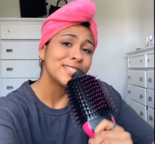 Une tiktokeuse vantant les mérites de la brosse lisseuse Revlon.  - TikTok