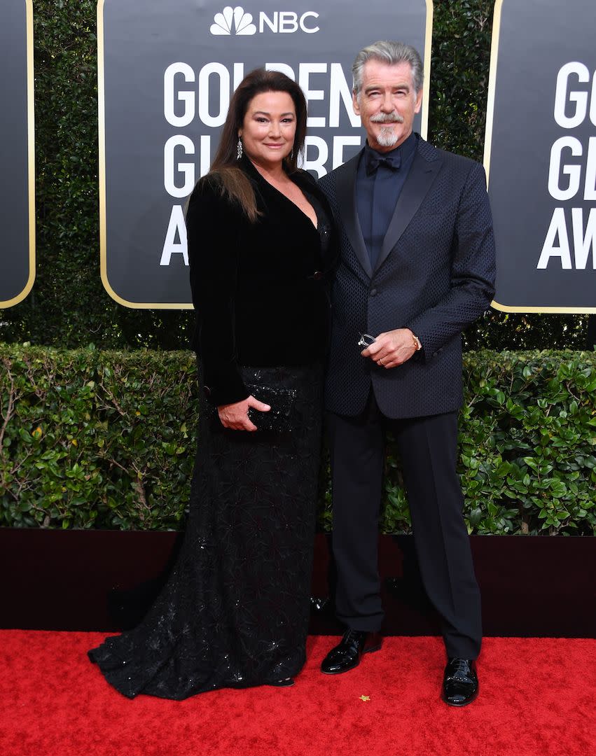 Pierce Brosnan chose a navy tuxedo for the ceremony while his wife, Keely Shaye Smith opted for a sweeping black sequin gown. <em>[Photo: Getty]</em>