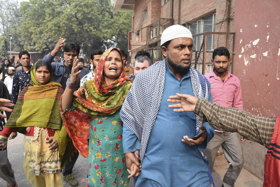 Relatives arrive for identification of bodies after a fire in a factory in New Delhi, India, Sunday, Dec. 8, 2019. Dozens of people died on Sunday in a devastating fire at a building in a crowded grains market area in central New Delhi, police said. Firefighters fought the blaze from 100 meters (yards) away because it broke out in one of the area's many alleyways, tangled in electrical wire and too narrow for vehicles to access, authorities at the scene said. (AP Photo/Dinesh Joshi)