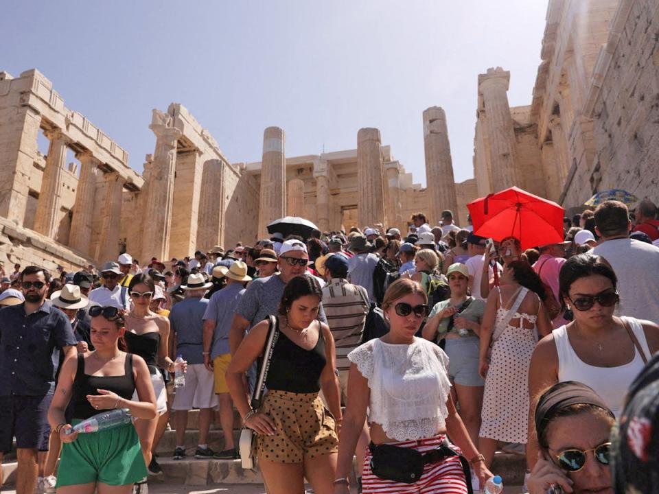 Visitors walk in front of the Acropolis, in Athens, as the Cerberus heatwave hit Greece on Saturday (Reuters)