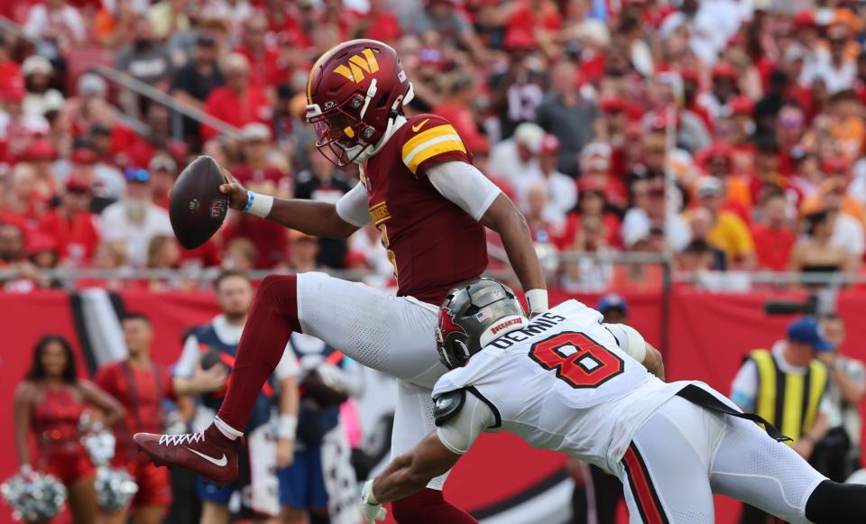 Sep 8, 2024; Tampa, Florida, USA; Washington Commanders quarterback Jayden Daniels (5) runs past Tampa Bay Buccaneers linebacker SirVocea Dennis (8) for a touchdown during the second half at Raymond James Stadium. Mandatory Credit: Kim Klement Neitzel-Imagn Images