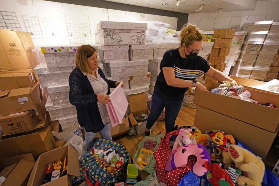 Jackie Crawford (left) and Amanda Findlay pack items into boxes at Glasgow Forge Shopping Centre to send to refugees fleeing the conflict in Ukraine (Andrew Milligan/PA) (PA Wire)