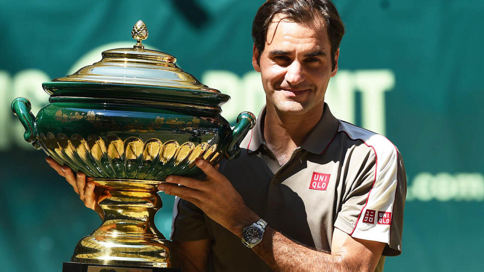 Roger Federer poses with the trophy. (Photo by CARMEN JASPERSEN/AFP/Getty Images)