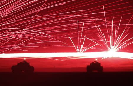 Tracer bullets ricochet off their targets as Japanese Ground Self-Defence Force tanks fire their machine guns during a night session of an annual training exercise at Higashifuji training field near Mount Fuji in Gotemba, west of Tokyo, August 19, 2014. REUTERS/Yuya Shino