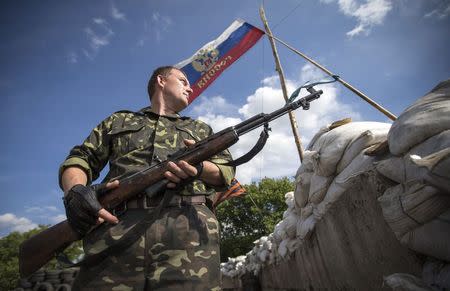 A pro-Russian separatist guards a road checkpoint outside the town of Lysychansk in the Luhansk region of eastern Ukraine, June 24, 2014. REUTERS/Shamil Zhumatov