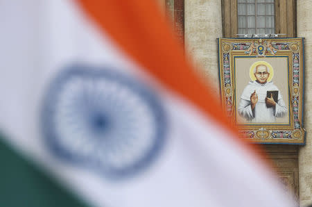 An Indian flag is seen in front of a tapestry with the image of new Indian saint Kuriakose Elias Chavara during a canonisation ceremony lead by Pope Francis, to make saints out of six men and women, in Saint Peter's Square at the Vatican November 23, 2014. REUTERS/Alessandro Bianchi