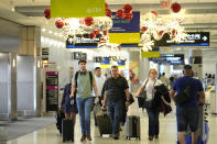 Travelers walk along the concourse at Miami International Airport ahead of the Thanksgiving holiday, Wednesday, Nov. 22, 2023, in Miami. (AP Photo/Lynne Sladky)