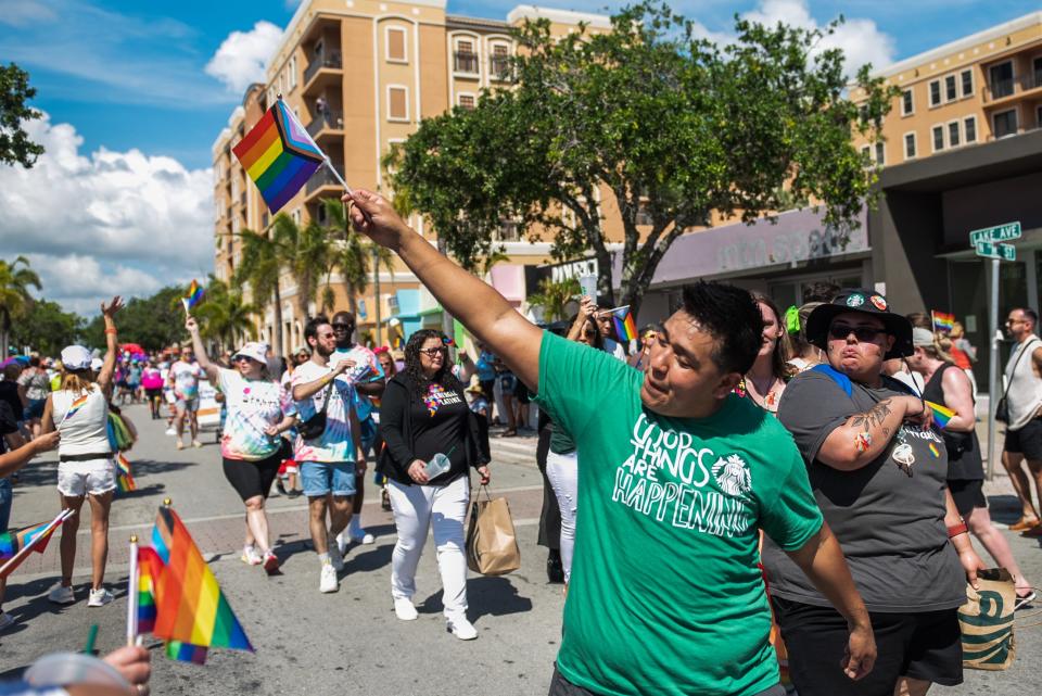 A member of the Starbucks group waves a pride flag during the Palm Beach Pride Parade, held Sunday in Lake Worth Beach.