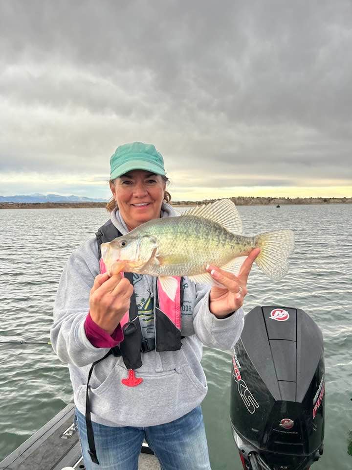 Pam Mitzner holds up the record-setting crappie she caught at the Pueblo Reservoir in 2023.