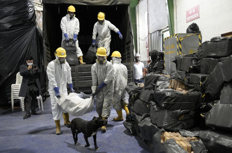 Workers carry bundles of drugs seized in various police operations, to be incinerated in Cayambe, Ecuador, Thursday, April 21, 2022. / Credit: Dolores Ochoa / AP