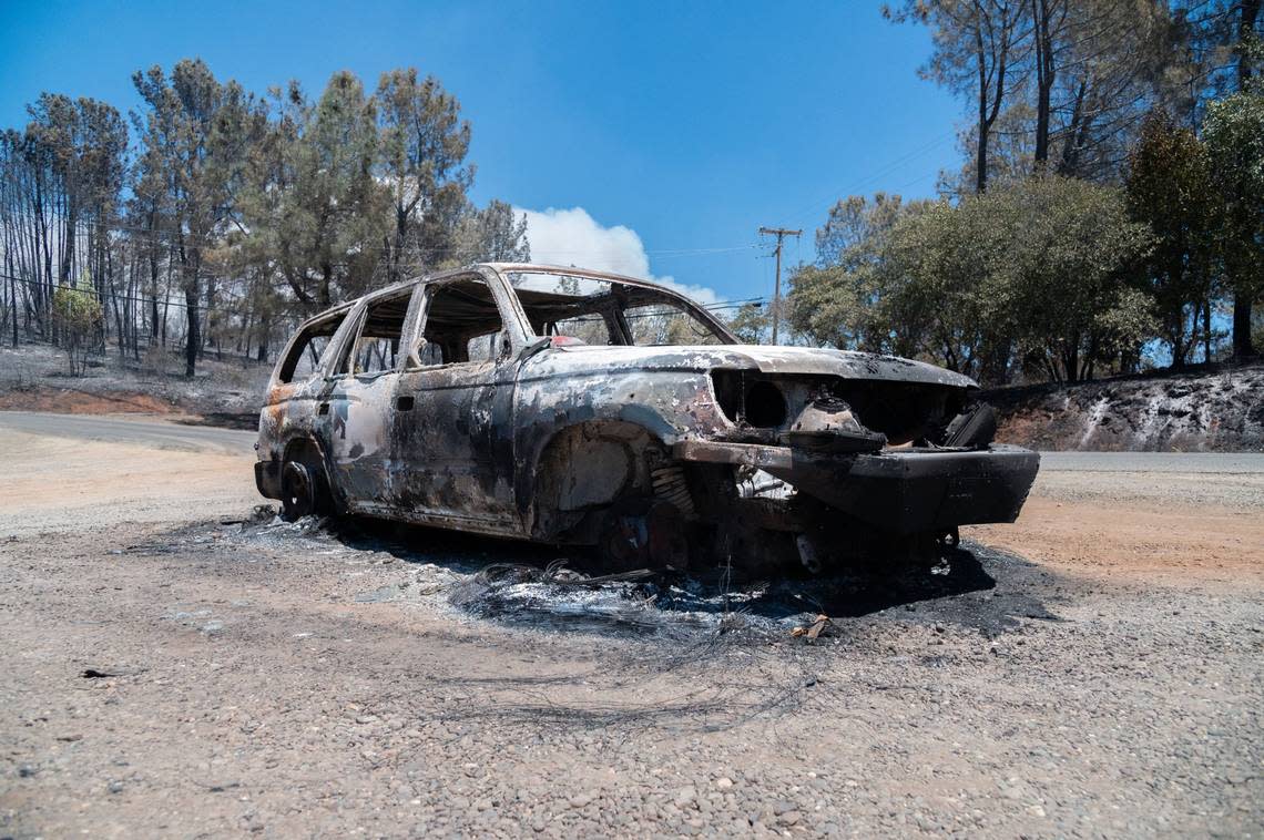 A car burned during the Park Fire sits near the intersection of Cohasset Road and Vilas Road in Cohasset on Friday. Nearby, other melted vehicles and pieces of metal sat on the scorched earth.