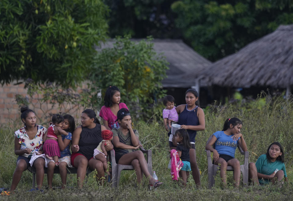 Women and children from the Macuxi ethnic group watch their family members play soccer in the Maturuca community on the Raposa Serra do Sol Indigenous reserve in Roraima state, Brazil, Saturday, Nov. 6, 2021. Bordering Venezuela and Guyana, it is bigger than Connecticut and home to 26,000 people from five different ethnicities. (AP Photo/Andre Penner)