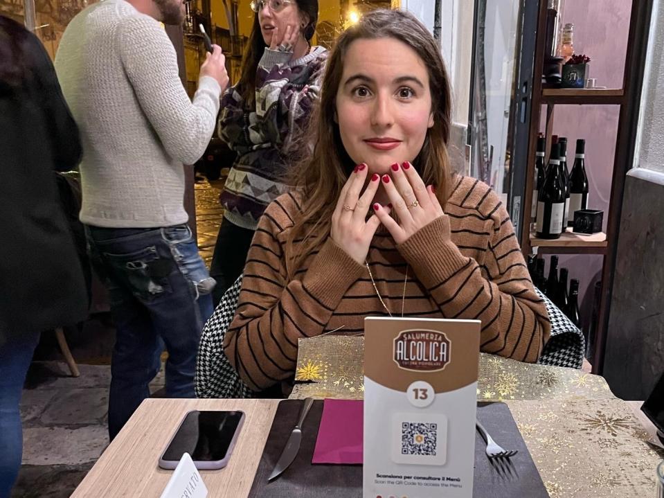 Federica Bocco, a woman, sitting at a restaurant in a brown sweater with her hands on her chin