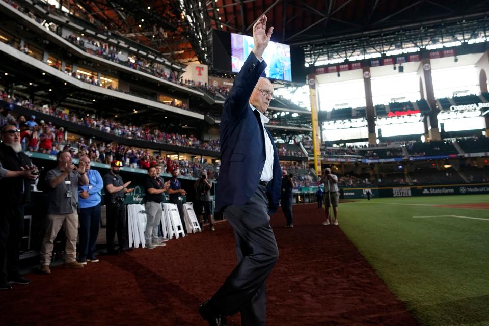 Nolan Ryan waves to the crowd as he takes the field for a screening of a documentary film about him.