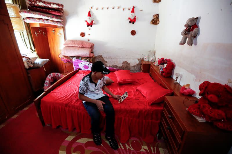 Iraqi teenager Hamid Saeed, who was mistreated by members of security forces, looks at his father's picture after being released from jail during an interview with Reuters at his home in Baghdad