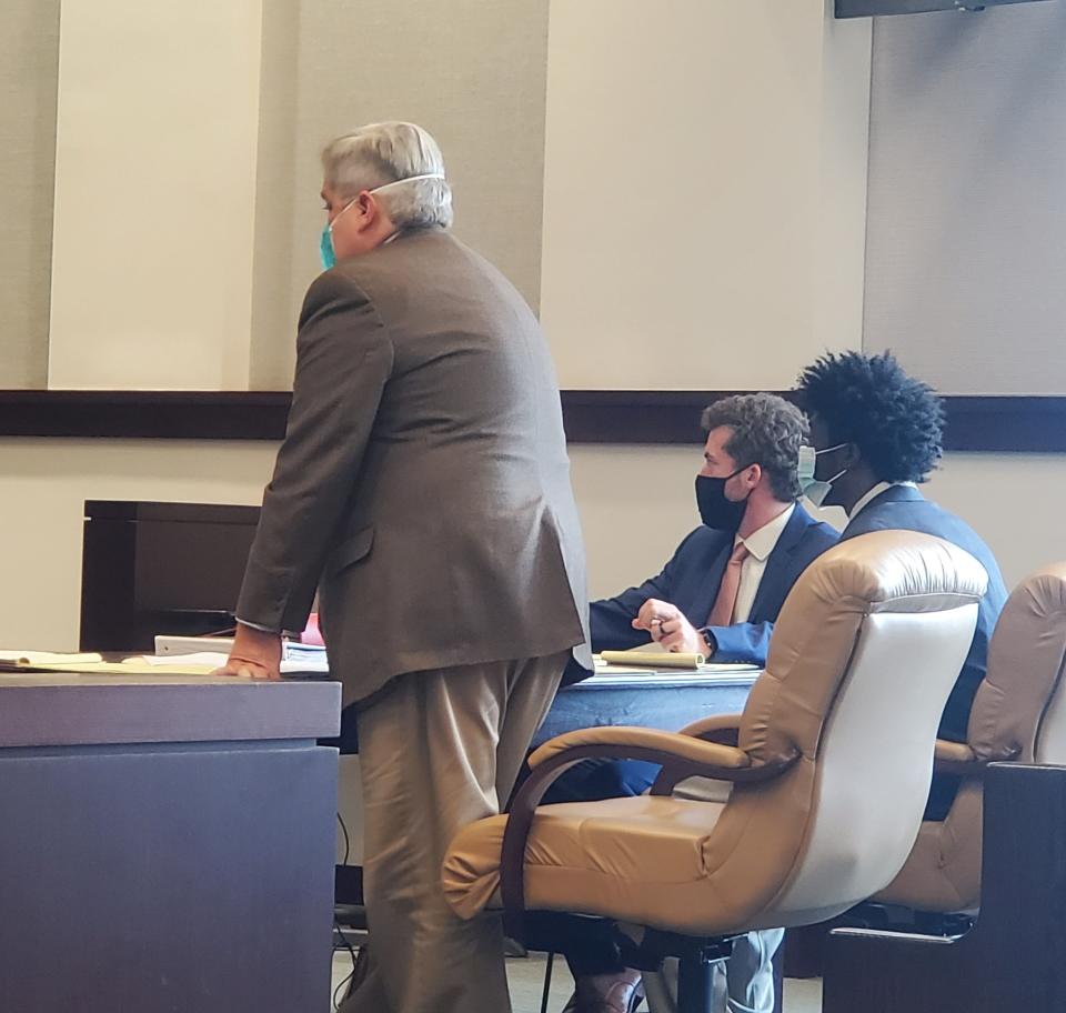 Defendant Ruez Hicks, seated and center, listens while his attorney addresses the court during his trial.