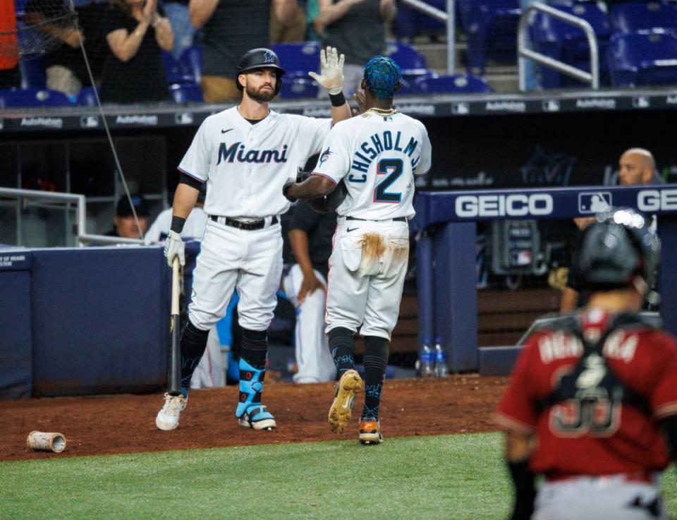 Miami Marlins second baseman Jazz Chisholm Jr. (2) is congratulated by third baseman Jon Berti (5) after scoring on a wild pitch by Arizona Diamondbacks relief pitcher Keynan Middleton (99) during the eighth inning of the baseball game at LoanDepot Park on Wednesday, May 4, 2022 in Miami, Florida.