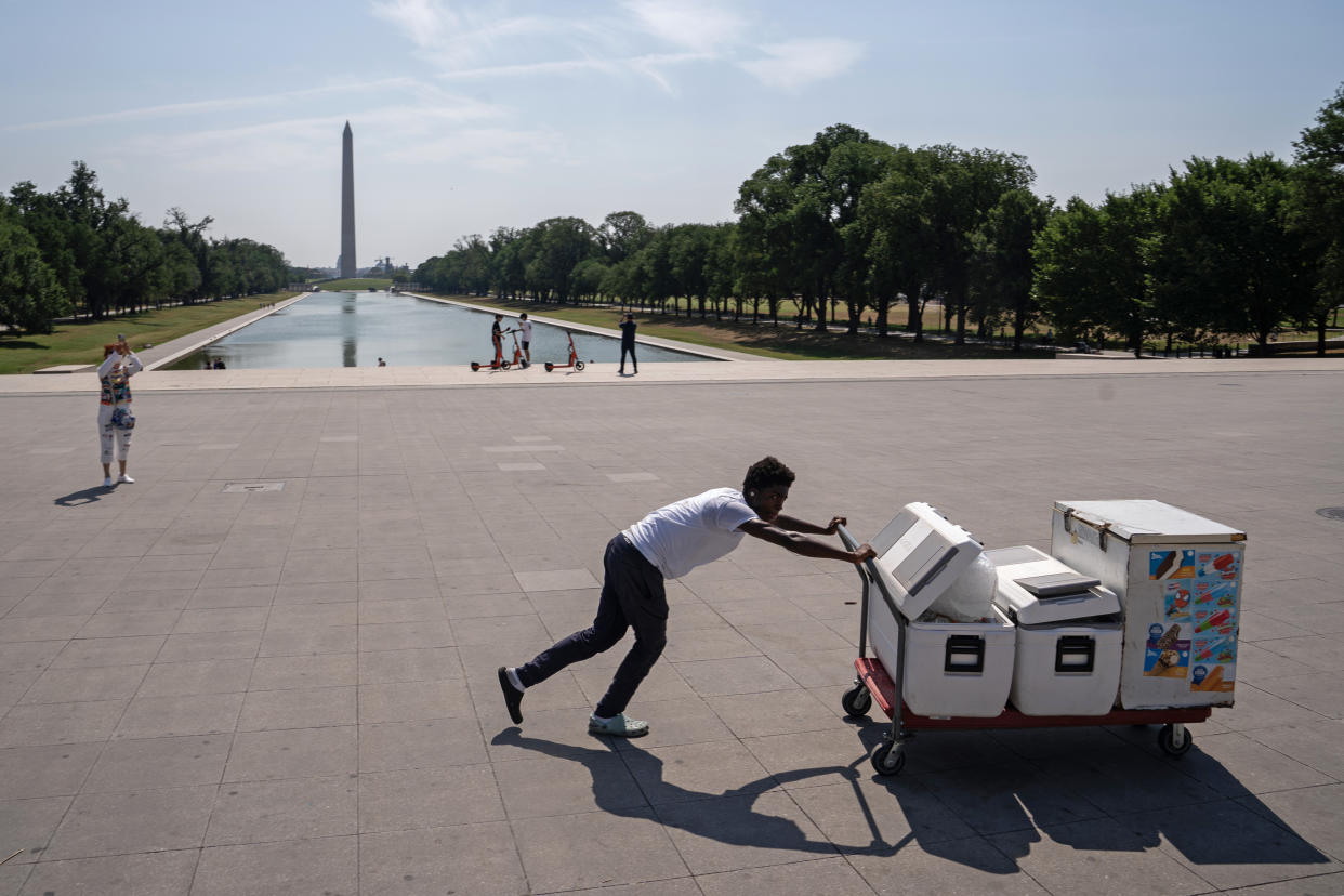 Kendall Brown pushes coolers filled with water to sell near the Lincoln Memorial during a heat wave on July 15 in Washington, D.C. 