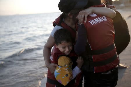 A migrant child is hugged by his mother, moments after arriving on a dinghy on the Greek island of Kos, August 18, 2015. REUTERS/Alkis Konstantinidis