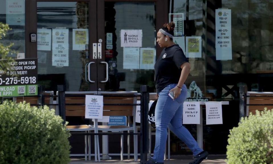A person passes a temporary take-out only restaurant on Friday in Phoenix. Though many facilities are closed, the governor has not issued a shelter-in-place order.