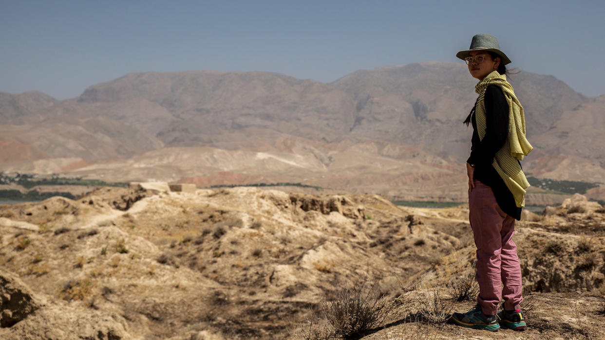  A woman wearing a pair of Patagonia Women’s Hampi Rock Pants turns to look back towards the camera. 