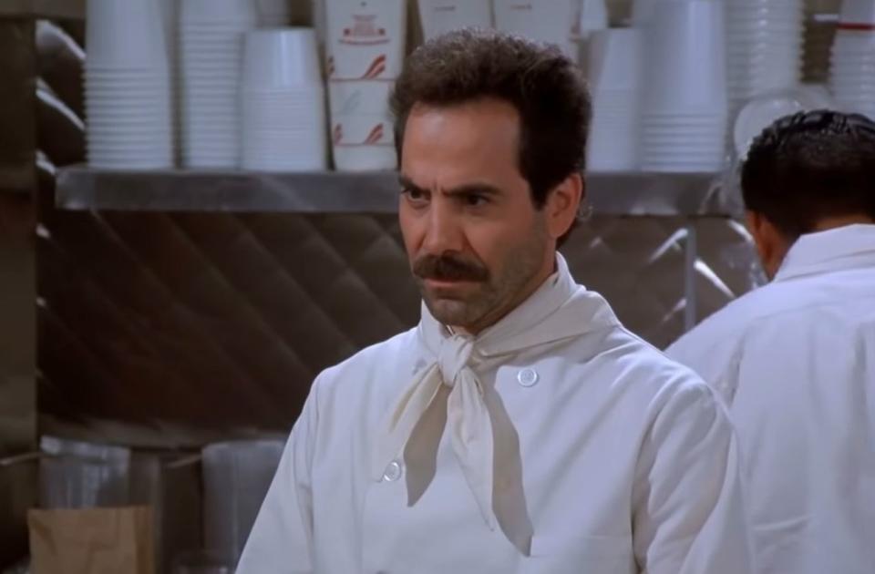 The Soup Nazi standing in his shop in "Seinfeld"