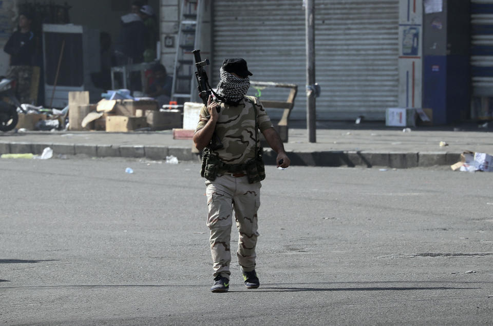 An Iraqi security forces member holds a teargas gun as they try to disperse anti-government protesters during ongoing protests in central Baghdad, Iraq, Saturday, Nov. 9, 2019. (AP Photo/Hadi Mizban)