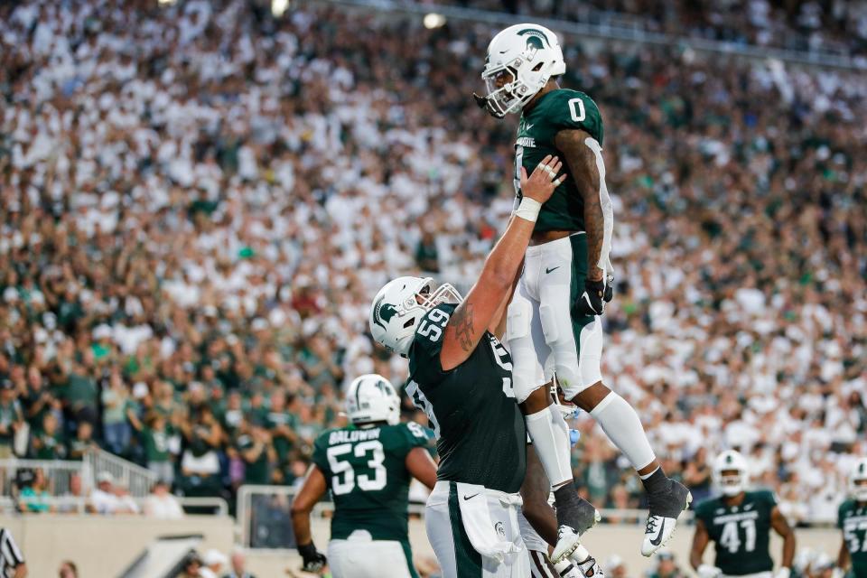 Michigan State wide receiver Keon Coleman (0) is lifted by center Nick Samac (59) after scoring a touchdown against Western Michigan during the first half at Spartan Stadium in East Lansing on Friday, Sept. 2, 2022.