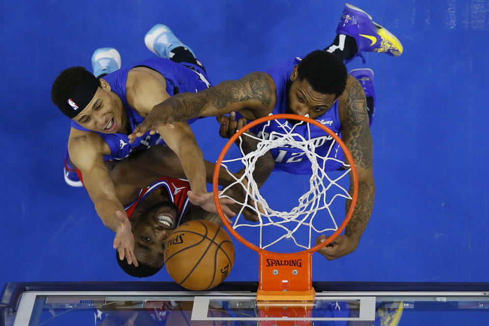 Philadelphia 76ers' Shake Milton, bottom, leaps for a rebound against Orlando Magic's R.J. Hampton, left, and Sindarius Thornwell during the second half of an NBA basketball game, Friday, May 14, 2021, in Philadelphia. (AP Photo/Matt Slocum)