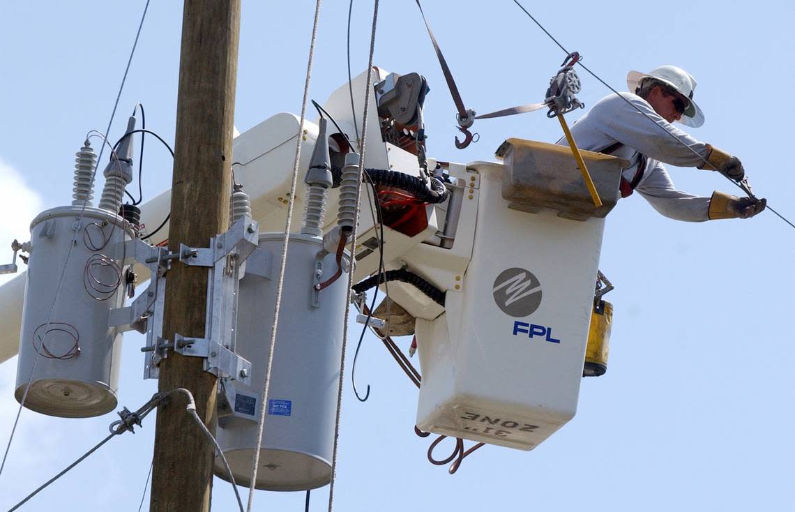 Florida Power & Light work on power lined in this file photo. The utility says it has 13,000 workers ready at 11 staging areas across the state to deal with outages in the wake of Tropical Storm Nicole.