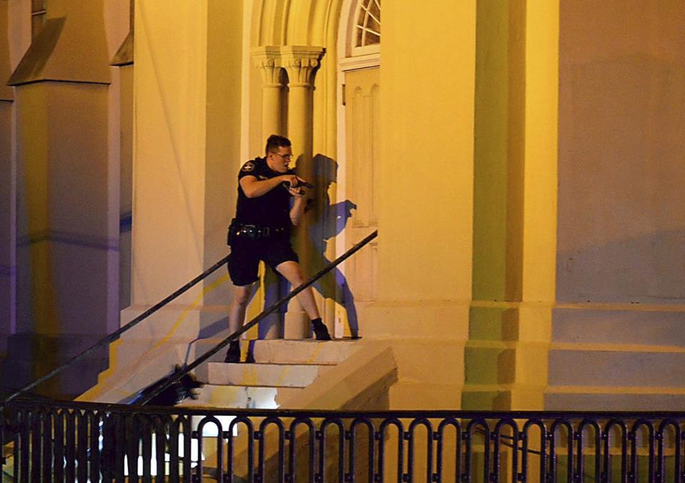 FILE - In this June 17, 2015 file photo, a Charleston police officer searches for a shooting suspect outside the Emanuel AME Church, in downtown Charleston, S.C. he new documentary, “Emanuel,” explores life after the tragic shooting took place on June 17, 2015, as family members, friends and the community try to heal through faith and forgiveness. (Matthew Fortner/The Post And Courier via AP, File)