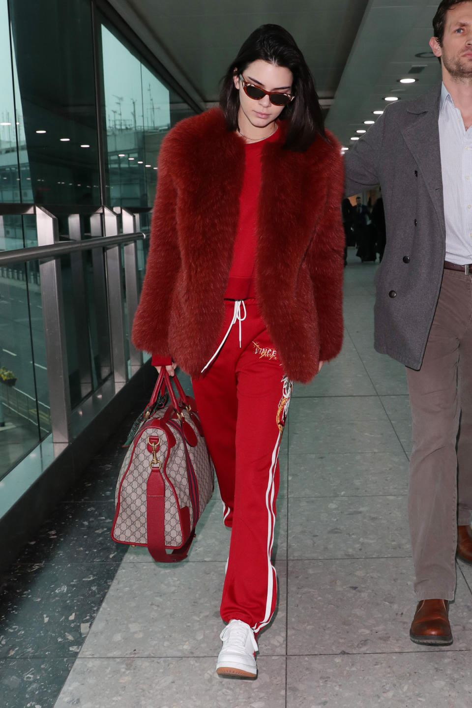 Kendall Jenner spotted in a Zeynep Arçay red fur coat at Heathrow Airport during London Fashion Week in February.
