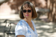 In this Friday, April 3, 2020 photo, Mica Sosa, a floor nurse at an oncology unit at a Phoenix hospital who moved into a friend's empty condominium a few weeks ago as a self isolation precaution due to the coronavirus, sits outside near her new temporary home in Phoenix. (AP Photo/Ross D. Franklin)