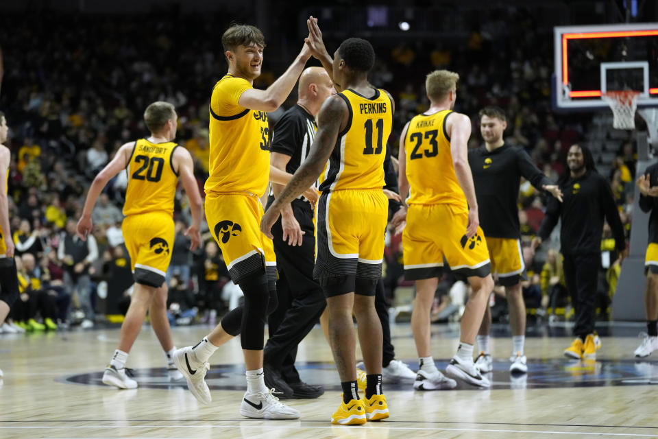 Iowa forward Owen Freeman (32) celebrates with teammate guard Tony Perkins (11) after making a basket at the end of the first half of an NCAA college basketball game against Florida A&M, Saturday, Dec. 16, 2023, in Des Moines, Iowa. (AP Photo/Charlie Neibergall)
