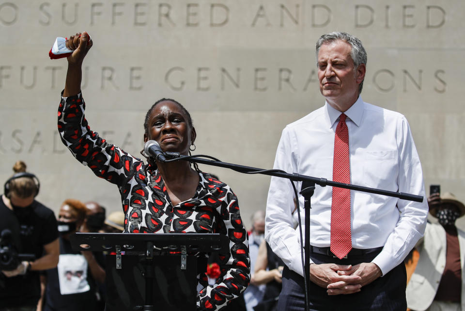 Chirlane McCray, left, wife of New York City Mayor Bill de Blasio, right, raises her fist in solidarity as she speaks during a memorial service for George Floyd at Cadman Plaza Park in the Brooklyn borough of New York, on Thursday, June 4, 2020. Floyd, an African American man, died on May 25 after a white Minneapolis police officer pressed a knee into his neck for several minutes even after he stopped moving and pleading for air. (AP Photo/John Minchillo)