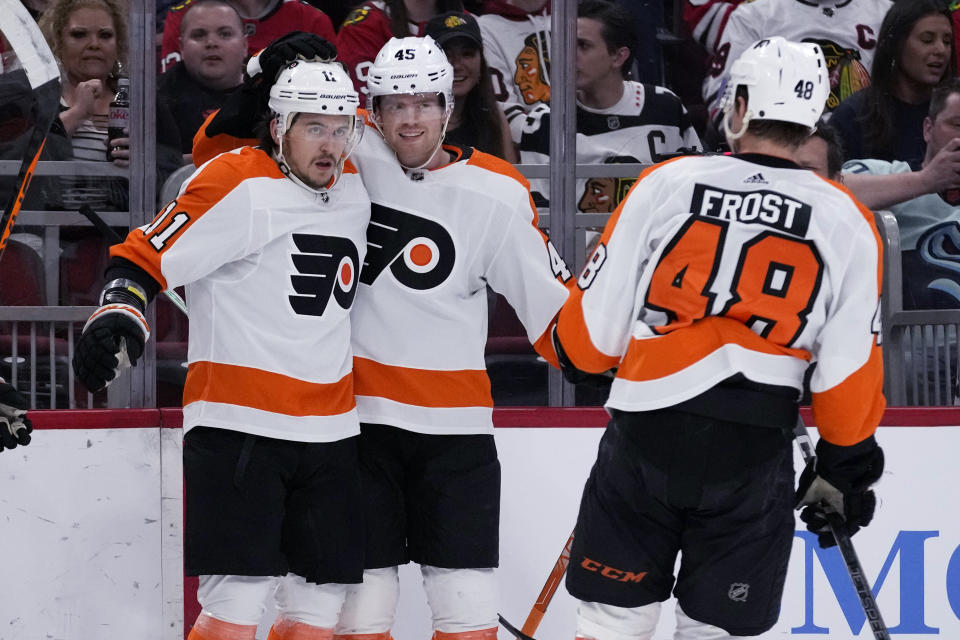 Philadelphia Flyers right wing Travis Konecny, left, celebrates with defenseman Cam York, center, and center Morgan Frost after scoring against the Chicago Blackhawks during the first period of an NHL hockey game in Chicago, Thursday, April 13, 2023. (AP Photo/Nam Y. Huh)